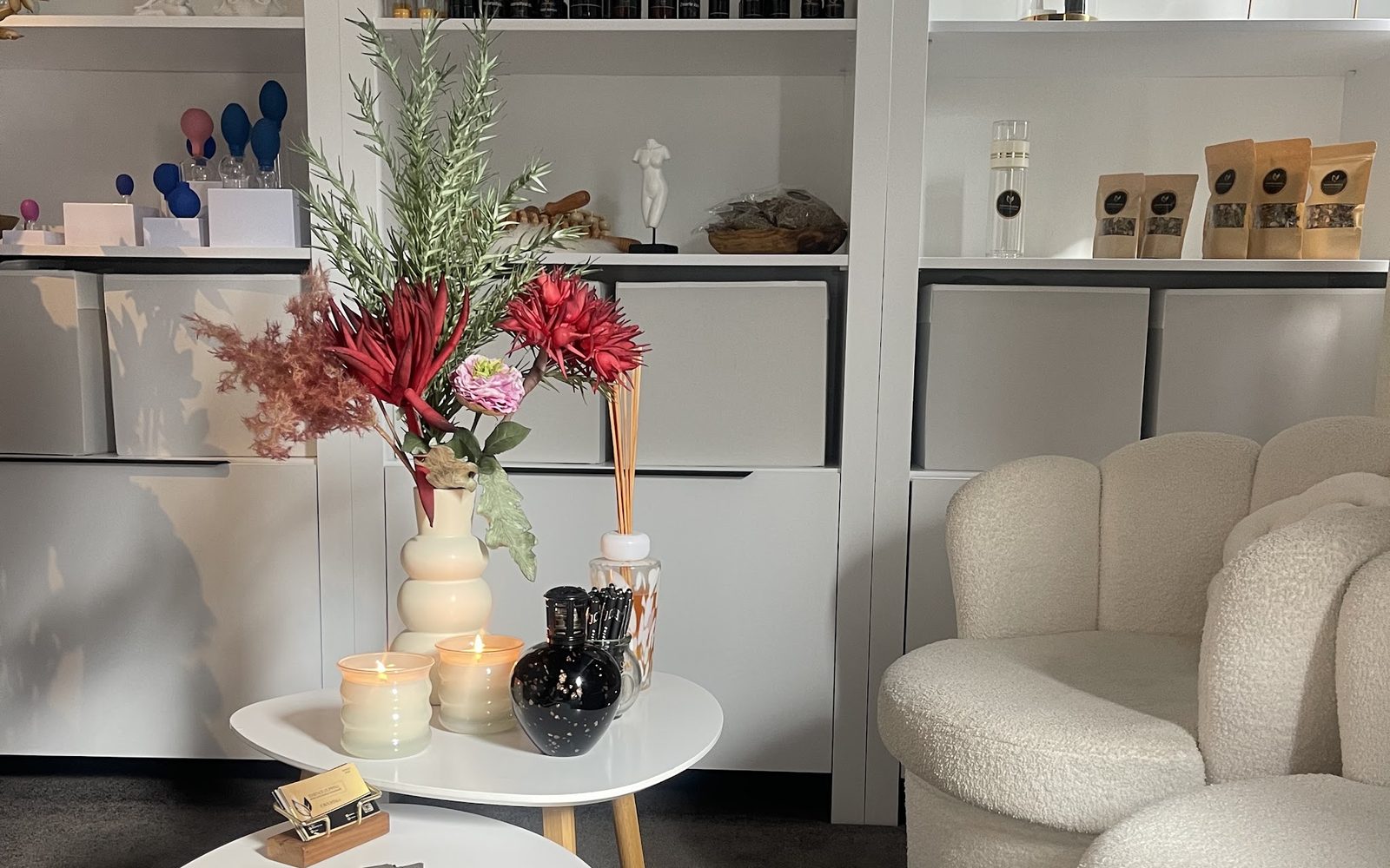 De praktijk van Essence cupping: witte kasten met eigen producten, bloemen en zachte stoelen
