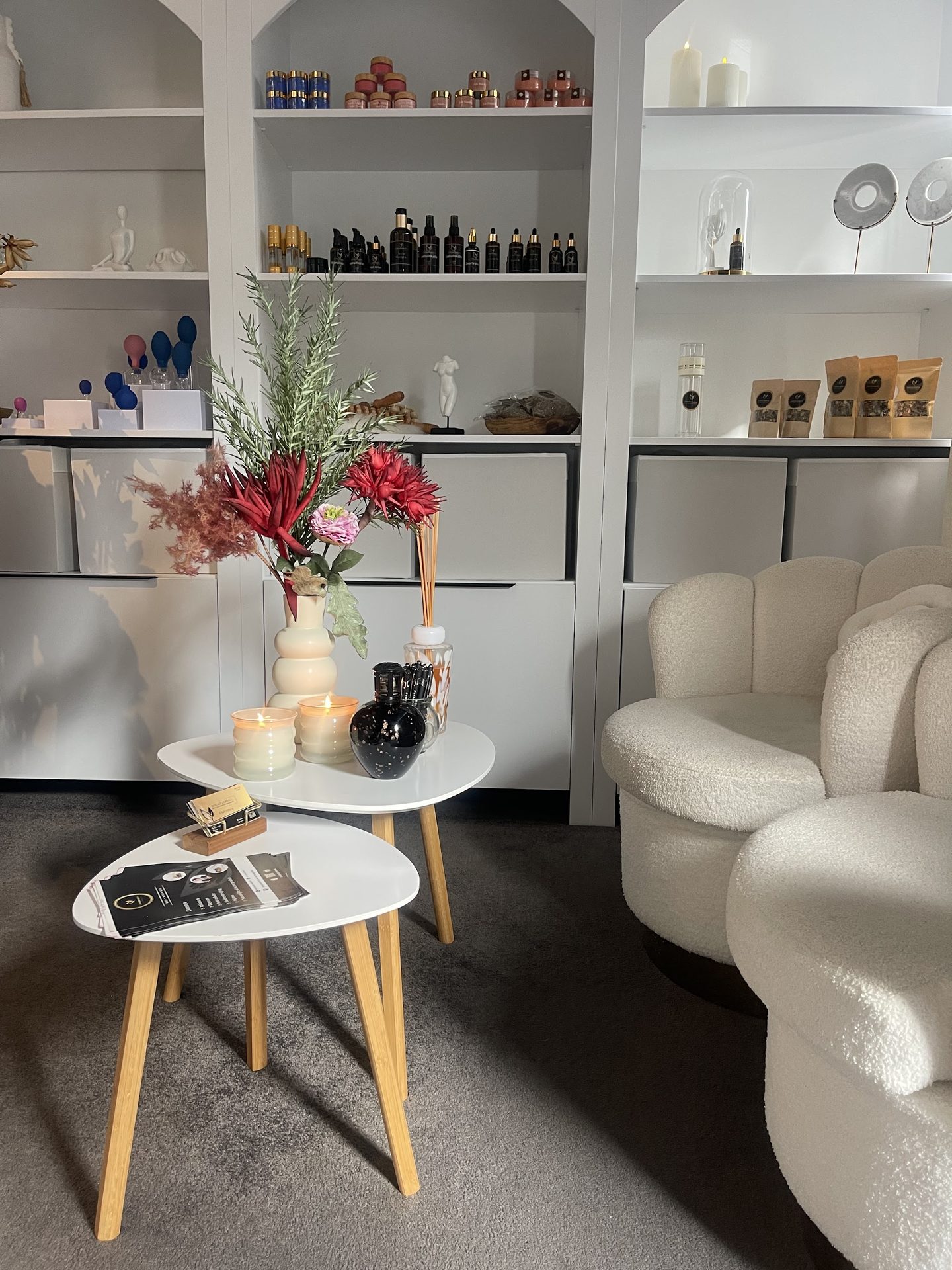 De praktijk van Essence cupping in Houten: witte boogkasten met producten, bloemen en twee zachte stoelen